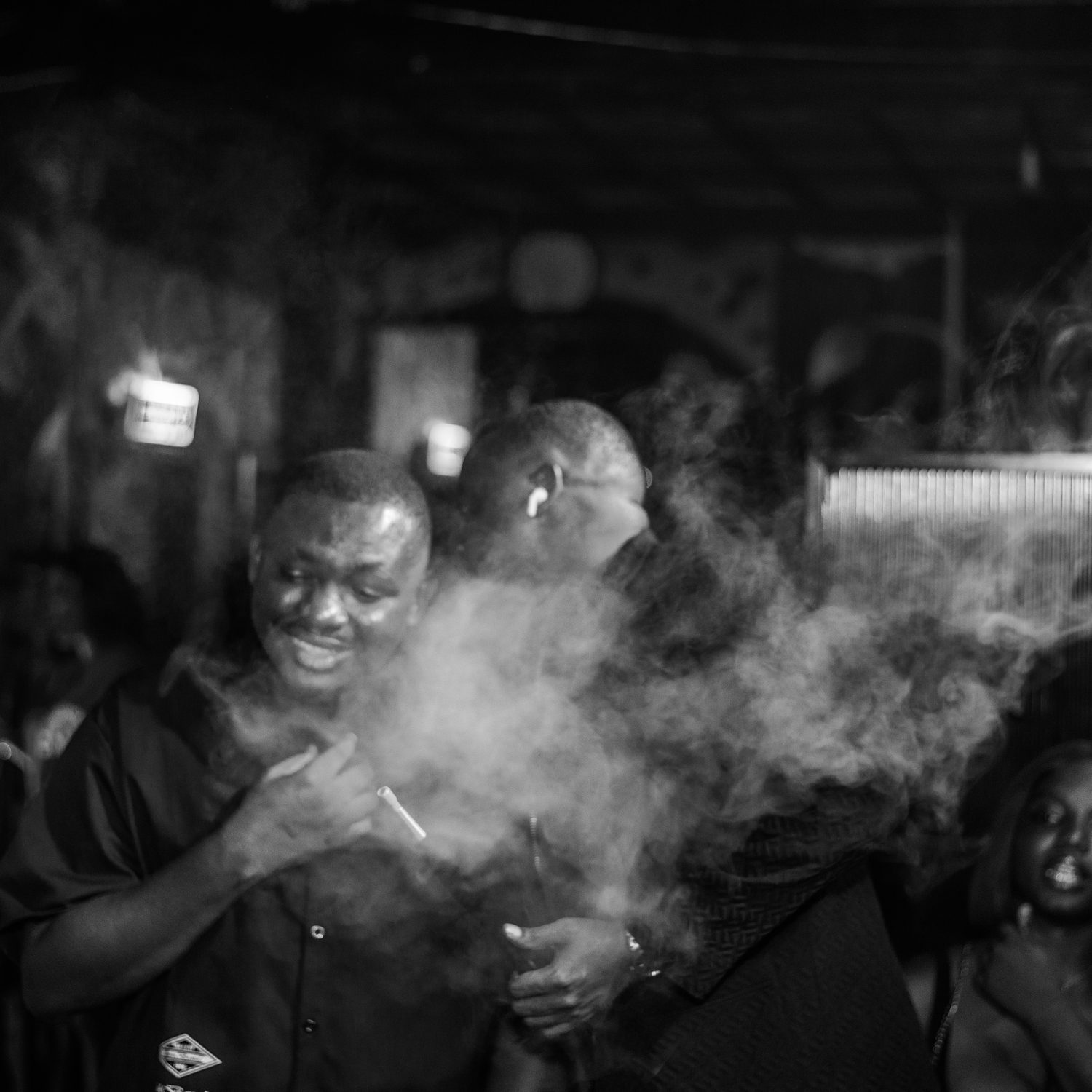 Two guests laughing through shisha smoke