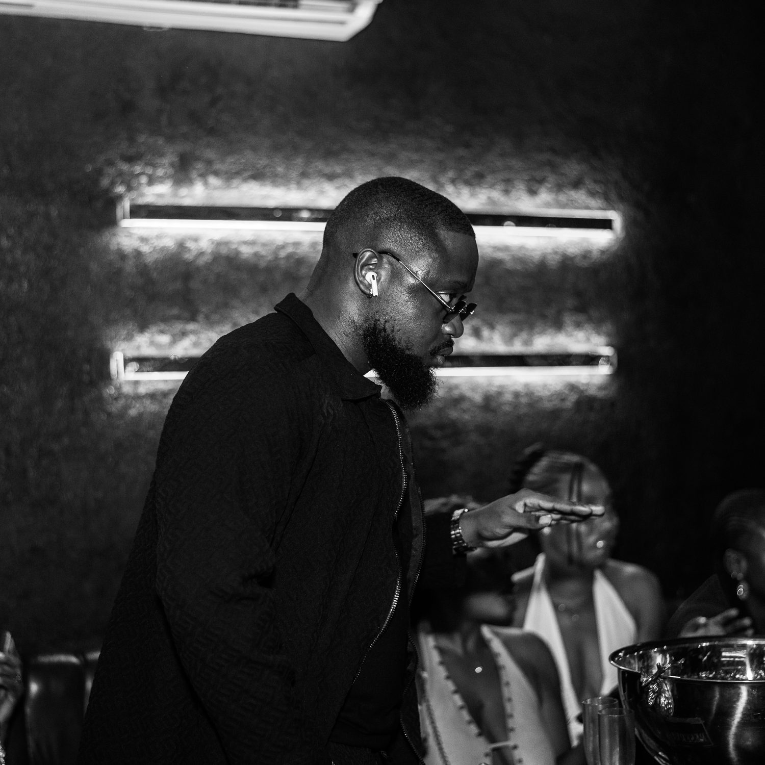 A guest in black beside the champagne bucket